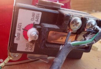 Here is a close up of thermostat connection. See the two ends of the black wire attached? I cut the hard plastic guard  at the bottom by the white arrow indicator and turned it down further so the water does not get too hot!