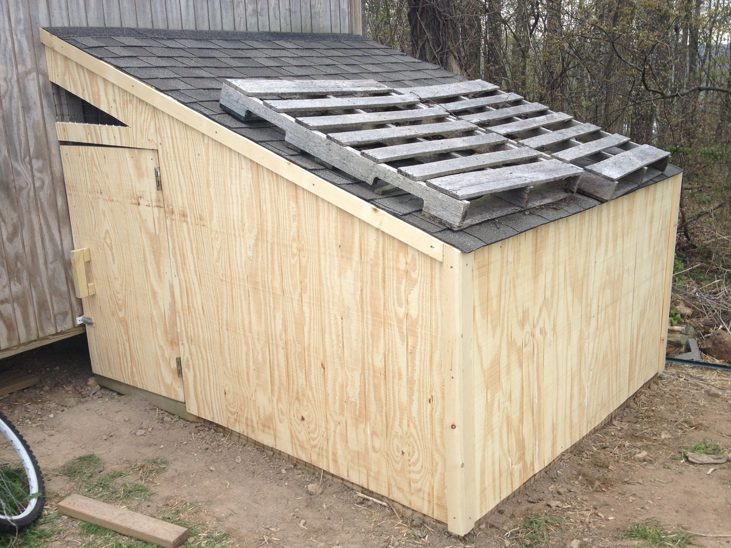 Here's the front side with the siding finished. I left an opening above the door for ventilation.  When I cut all of the original wire off the coop, I left that section in place with this in mind.