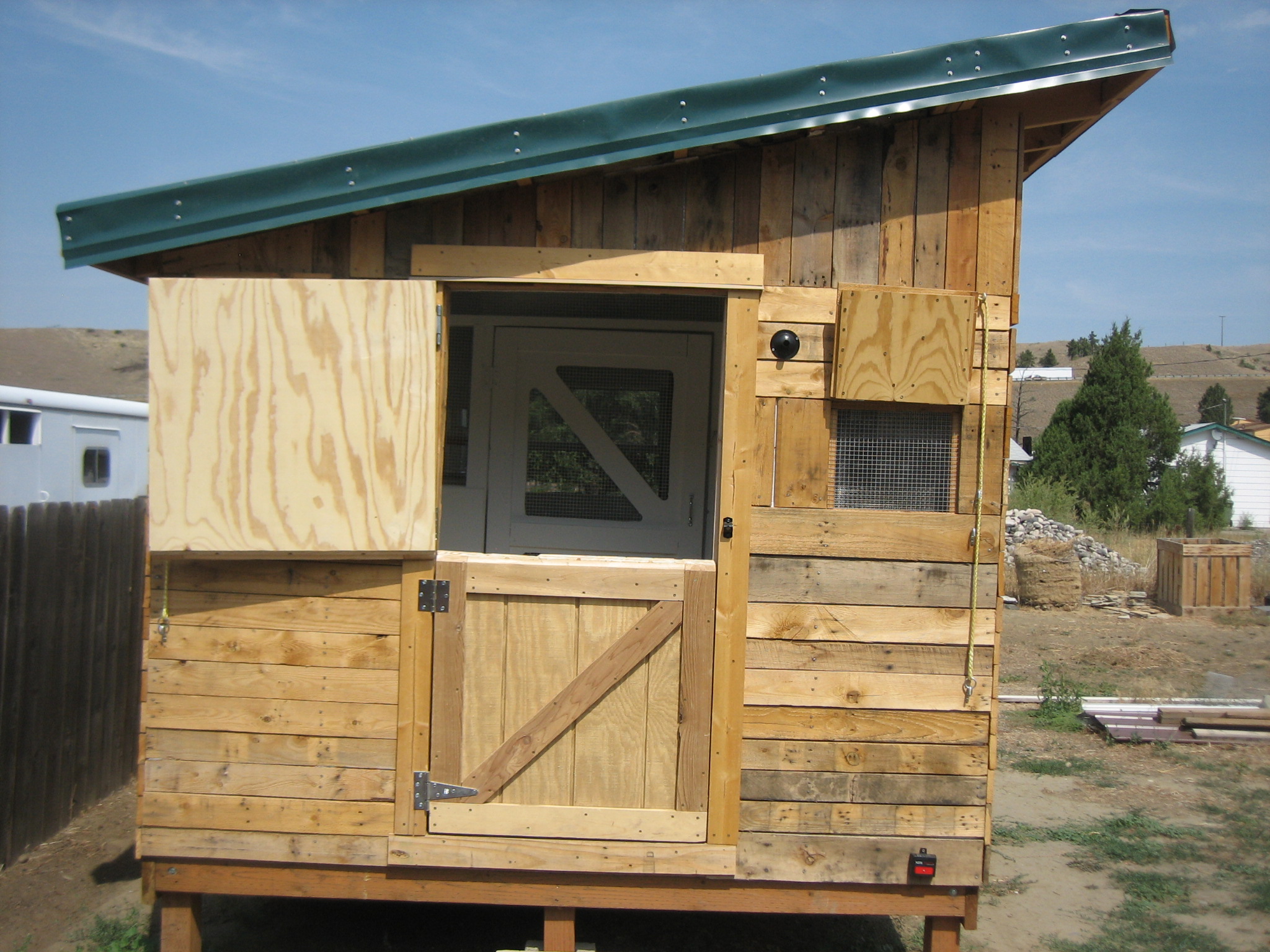 How it looks when opened up for light and breeze.  When using the left over steel we had for the roof, we did not have all the right pieces and parts, so we just extended the steel panels over the edge and screwed them down.  From an airplane you would see the roof is 2 colors of steel....that is what happens when using leftovers!