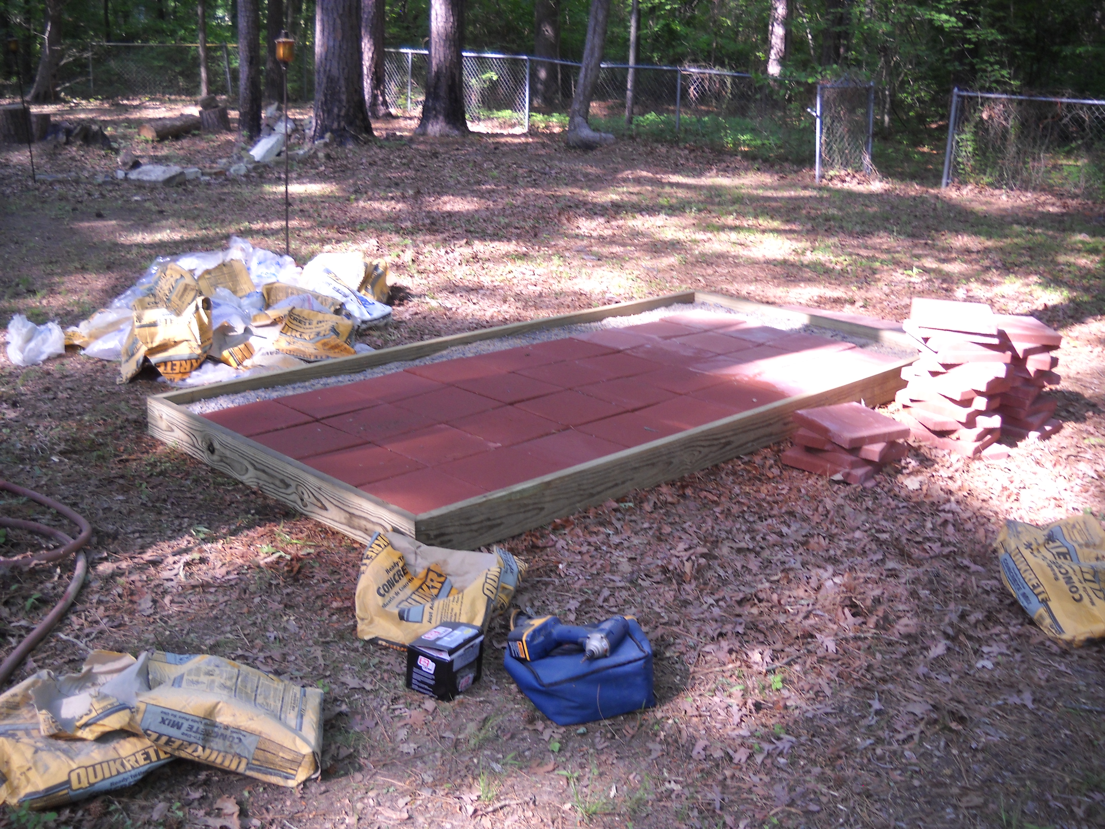 I first built the foundation.  I used a mixture of  sand, gravel, dirt and a bit of portland cement to build up a "hardpan" and then put the pabving stones on top.  This will be hard enough that predetors cannot tunnel through, but will drain when I spray it off.