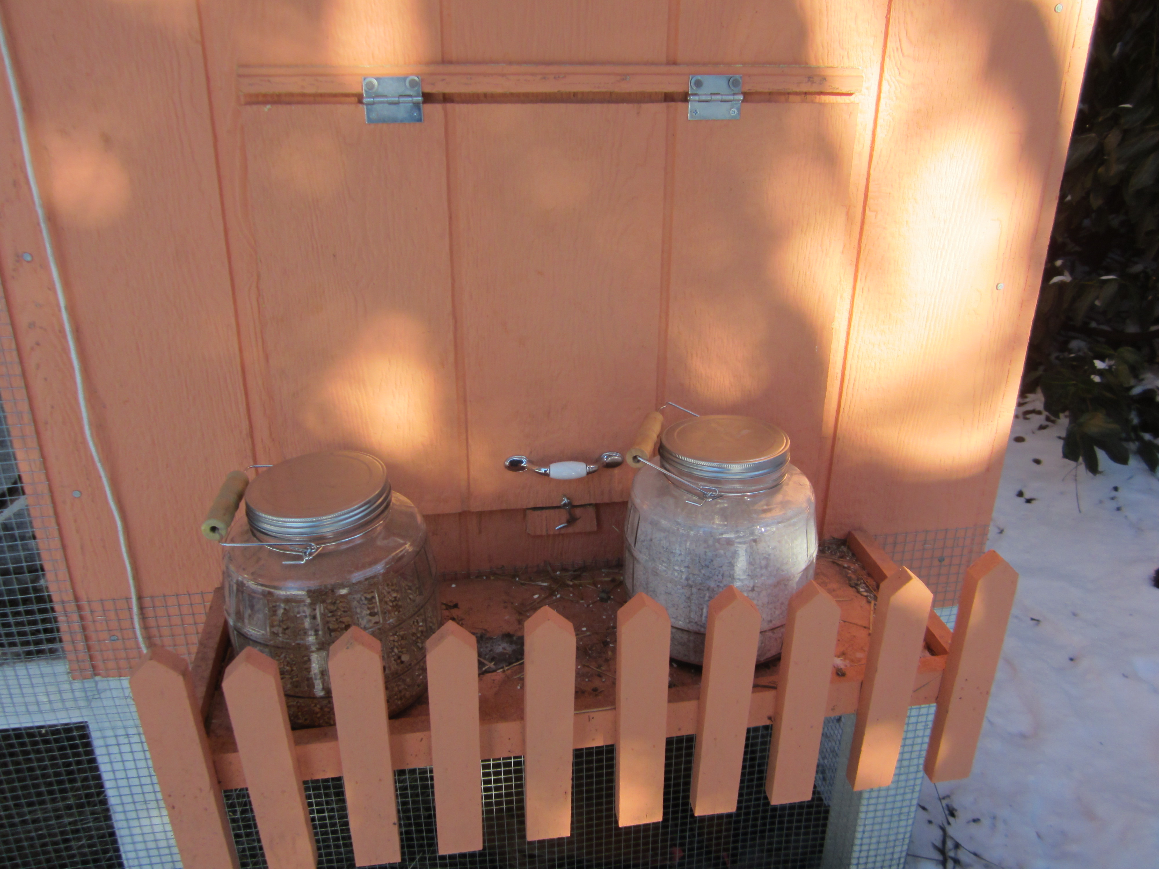 I love my shelf! It's right in front of the nest box door and is supper handy. Here are my containers for scratch and grit/oyster shells, they have handles on them so they can be carried