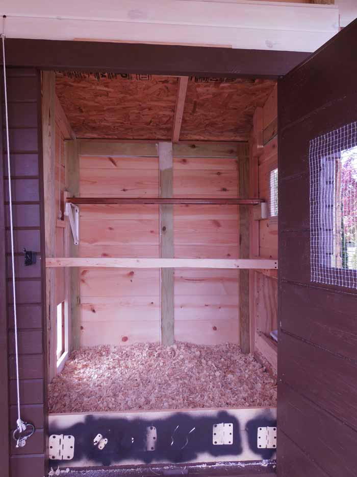 Inside of the coop, still a work in progress at this point. We have since added a poop board under the upper roosting bar (one of the best things we've done!) and bracket to hang a feeder below the poop board.