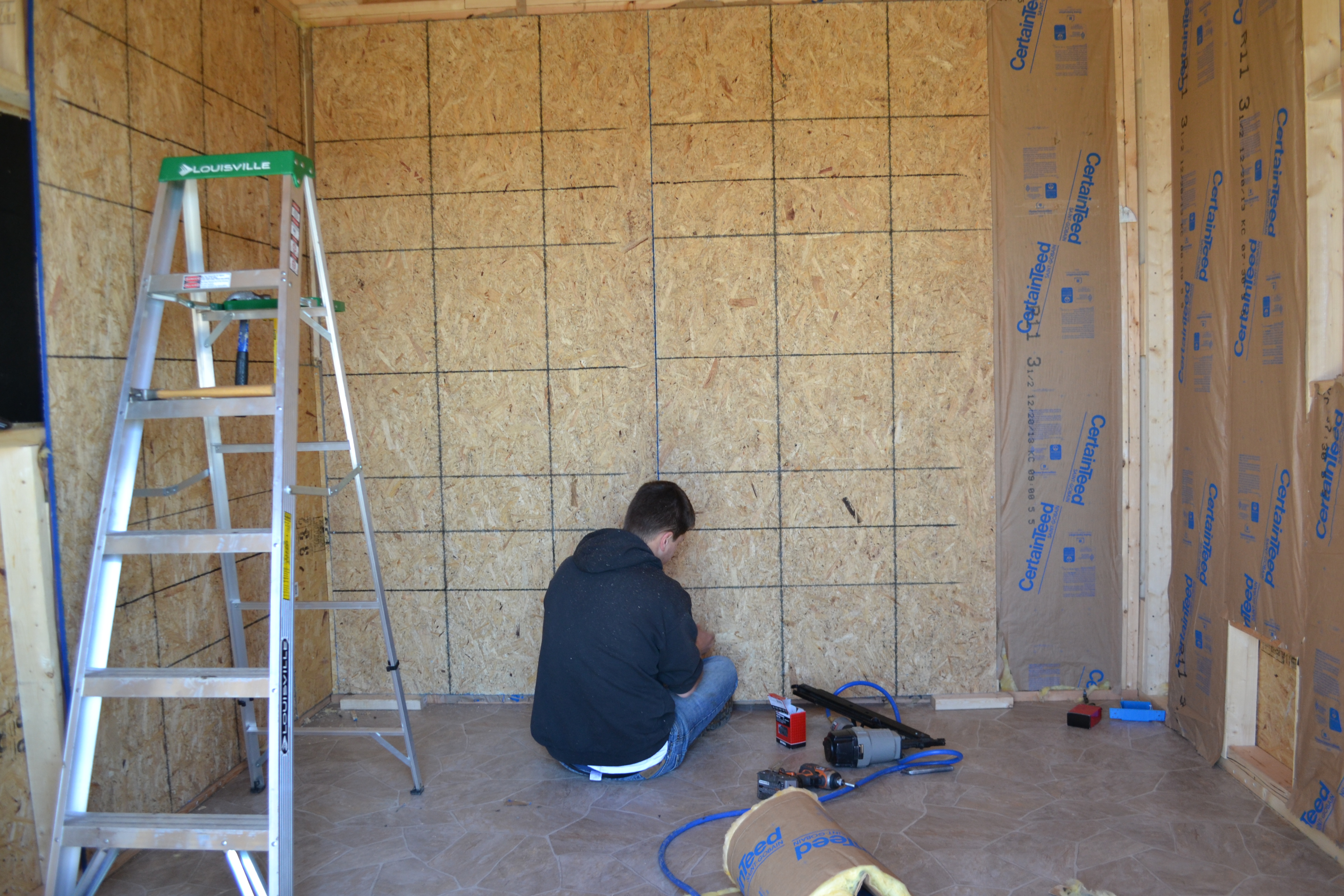Insulation is done and sheeting is going up. We also have another vinyl layer that will go up over this for easy clean up, but it is too thin to use without something more rigid behind.