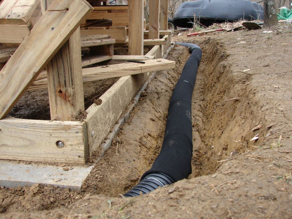 Laying perforated drain pipe.