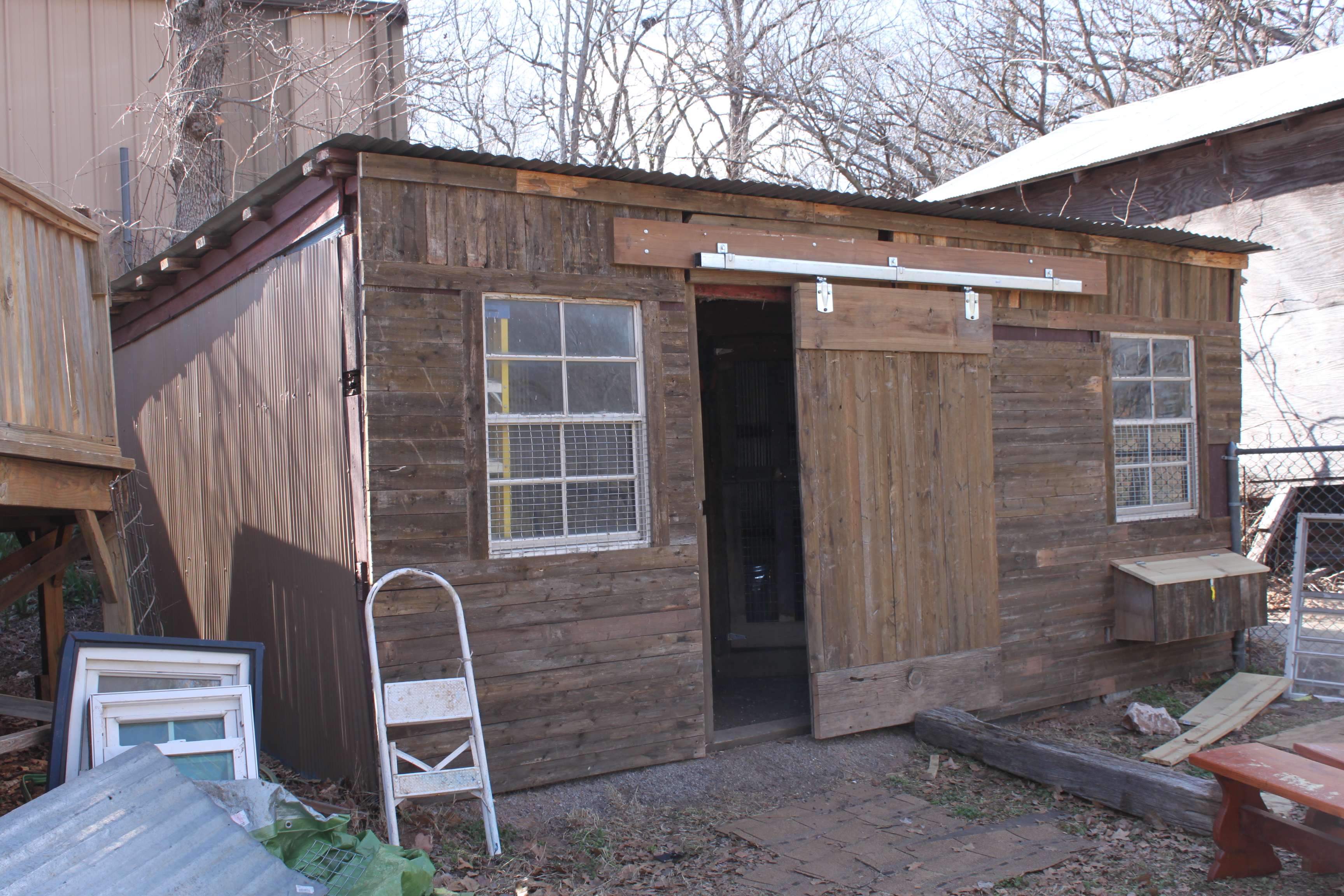 My coop afterward!  I added windows, a sliding door, siding made from old fence panels, and painted the side brown instead of blue (I had always hated the blue).