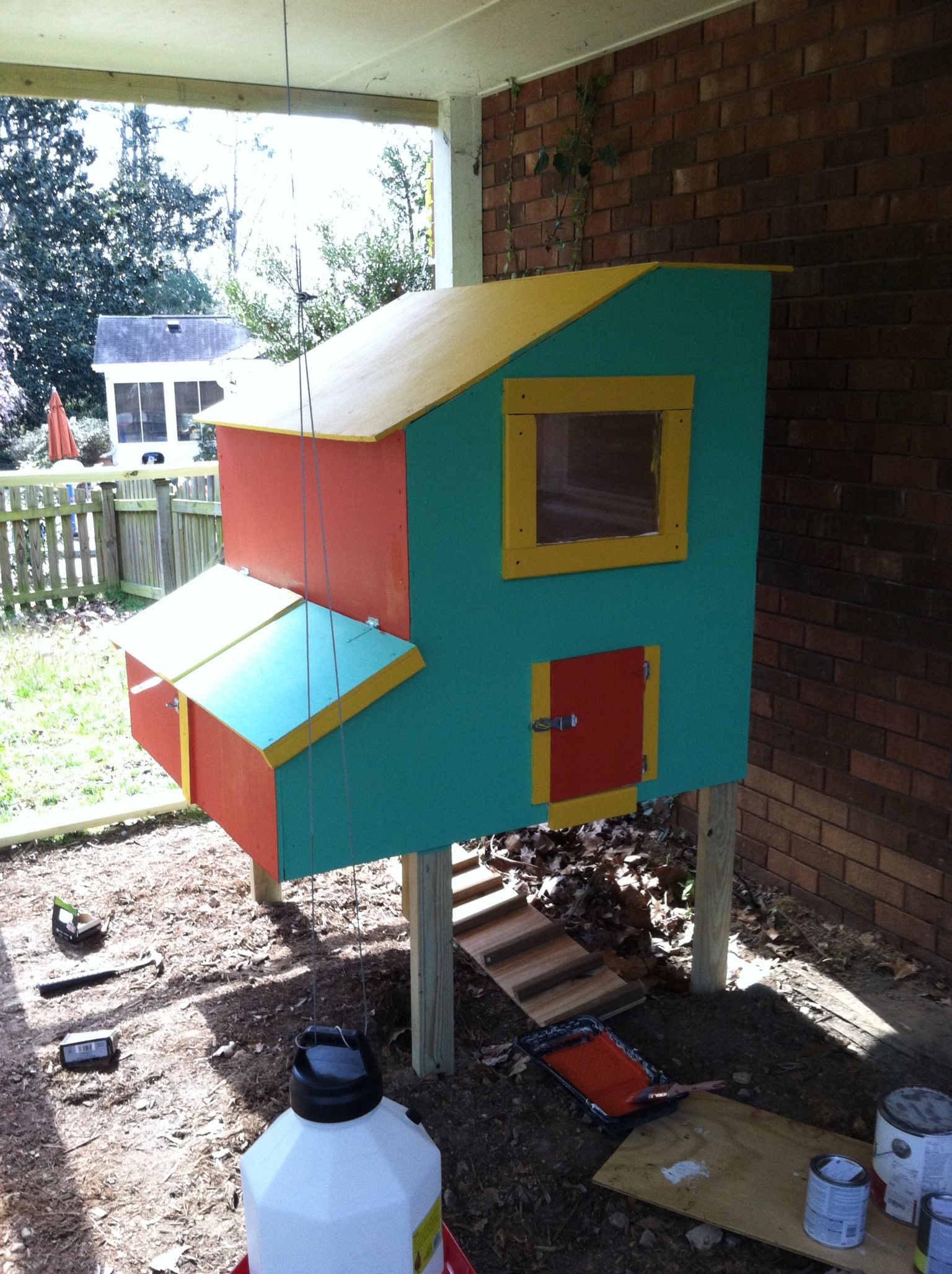 My new coop. I built this back in March of this year ('13) out of 1/2 inch oak plywood that I got for $22 per 4x8 sheet!! I painted it red, gold, and aqua for an island feel. It is enclosed in a 225 square foot area created by my master bedroom which juts out over the backyard. I framed in the areas between the support posts and covered it with hardware cloth. As you can see, the roof is also oak plywood. Since I have complete coverage from the elements, there was no need for any typical roofing. There are three nest boxes which is plenty for my nine chickens.