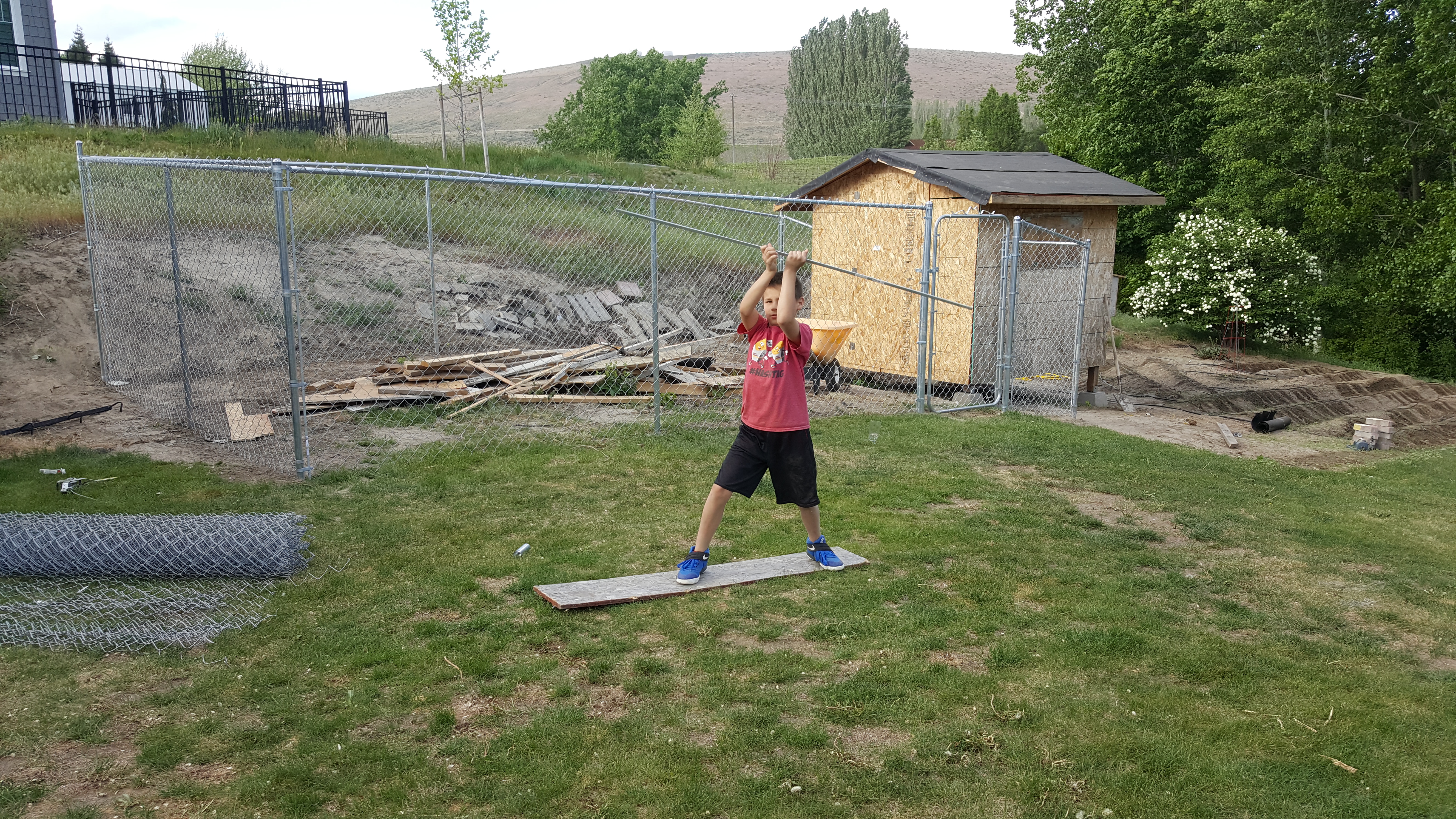 My oldest son practicing how to poke an eye out techniques in front of our coop in progress
