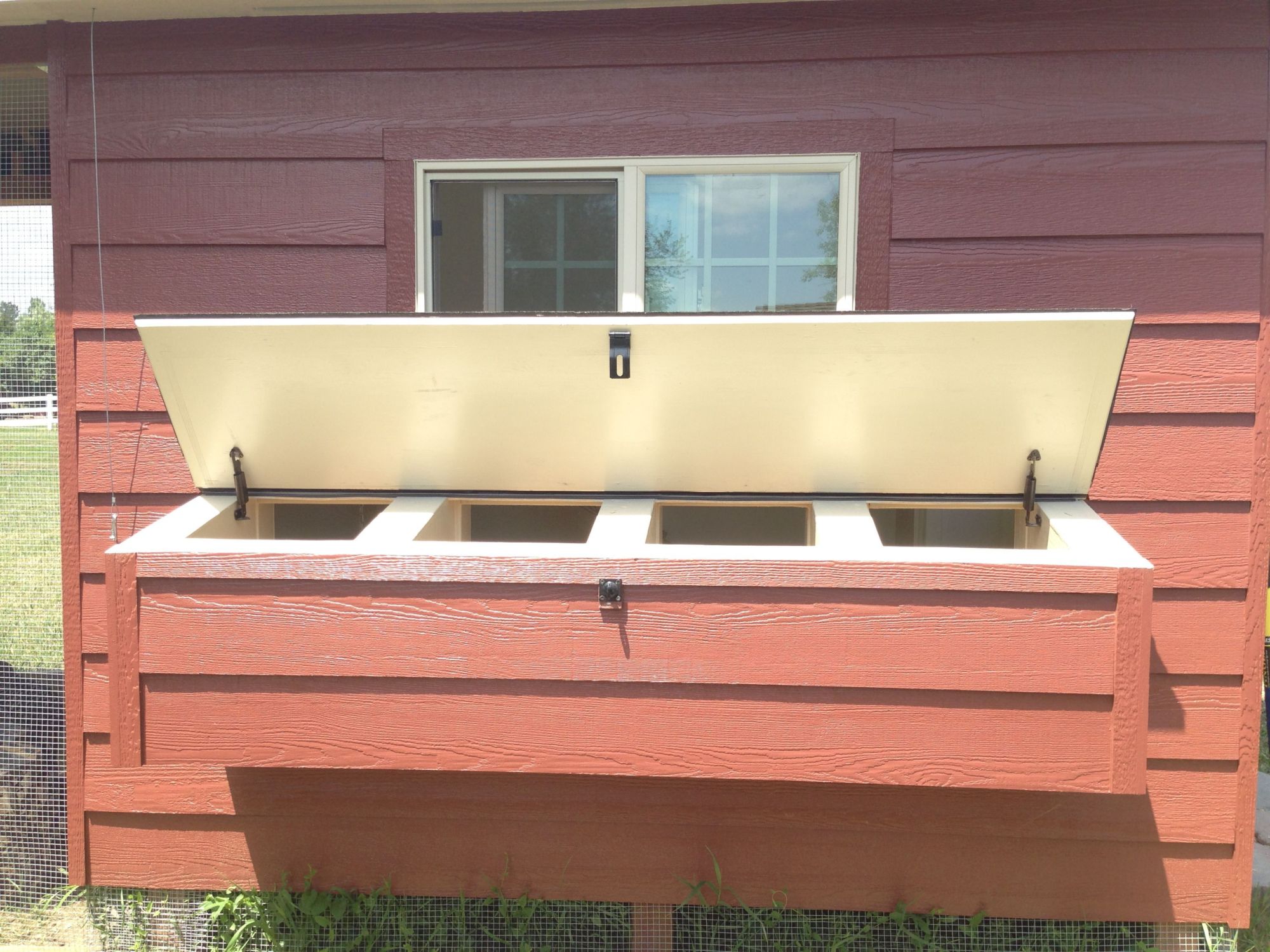 Nesting boxes prop open.  Had a difficult time making this part water tight.  It kept leaking through the hinge.  Finally achieved it by laying some rubber over the hinge, then laying shingles over it and trim board over other side.  I think it looks even better that way because the hinge less noticeable now too!  You might be able to see this in the next pic where lid is closed.