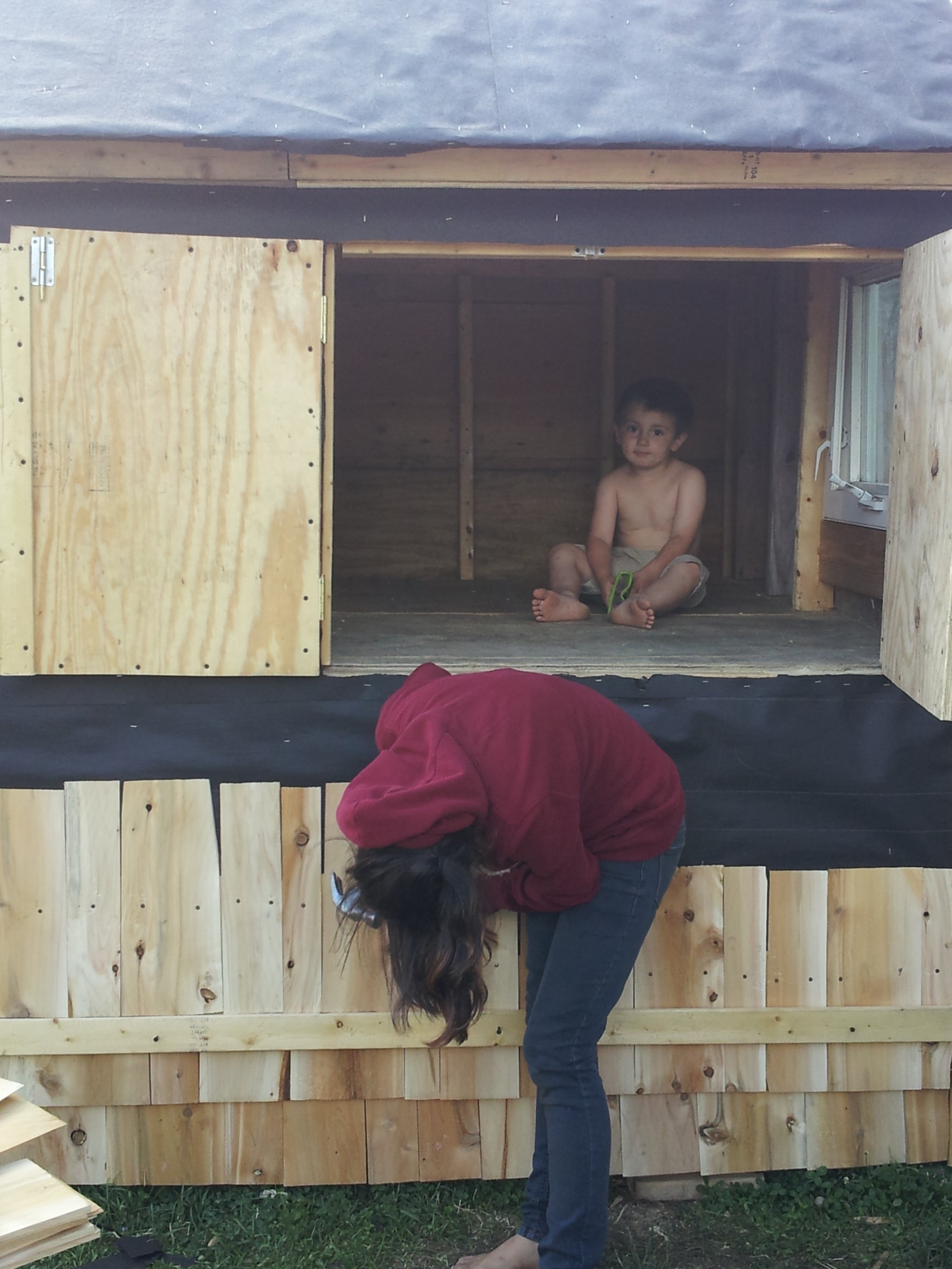 oh gosh..why are they tilted.. ok.. well here is my son modeling the interior coop.. and 13 yr old daughter helping to shingle it.