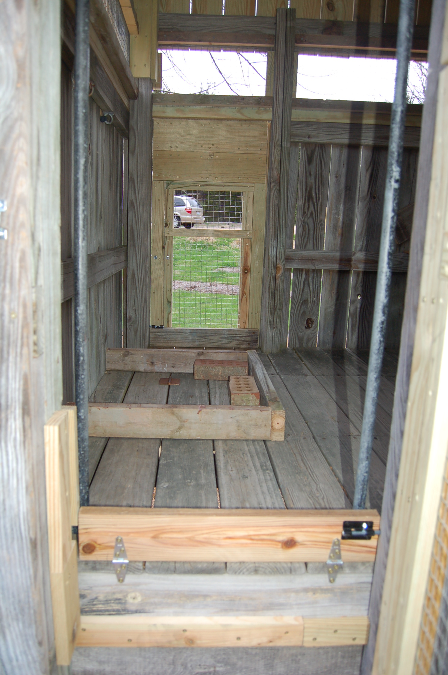 Originally we had the hole in the floor for the ramp here (edged by the 2x4's to hold back the bedding).  We ended up moving the hole and now the feeder is hanging above this location.  We put the hole under the poop board - works out perfectly!