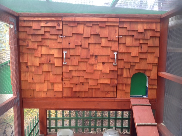 Our coop viewed from the west.  This is the human access door to the hen house and also the chicken access door and ramp.  The green portion of the chicken access door slides up via a cable/pulley assembly accessible from the front of the coop.