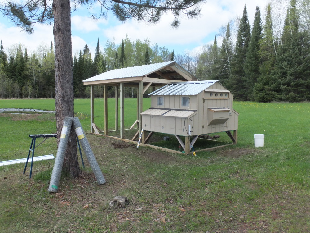 Our first coop built spring 2013, has three sides that open for cleaning, all insulated for Canadian winter, windows and vents that open on sliding rails, and "egg-hatch" sections that open for egg removal.  The metal roofing reflects excess solar heat all summer.  Feed bin on the rear door allows us to go away for a few days at time. Coop is 6' x 8' x 5' tall (on 2' legs) and the run is 8' x 12' -shown here under construction.