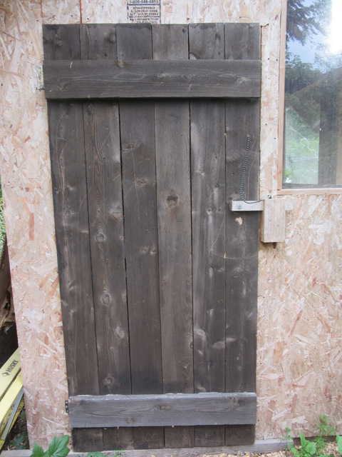 Plank door with draw latch on the new Tudor style chick house.