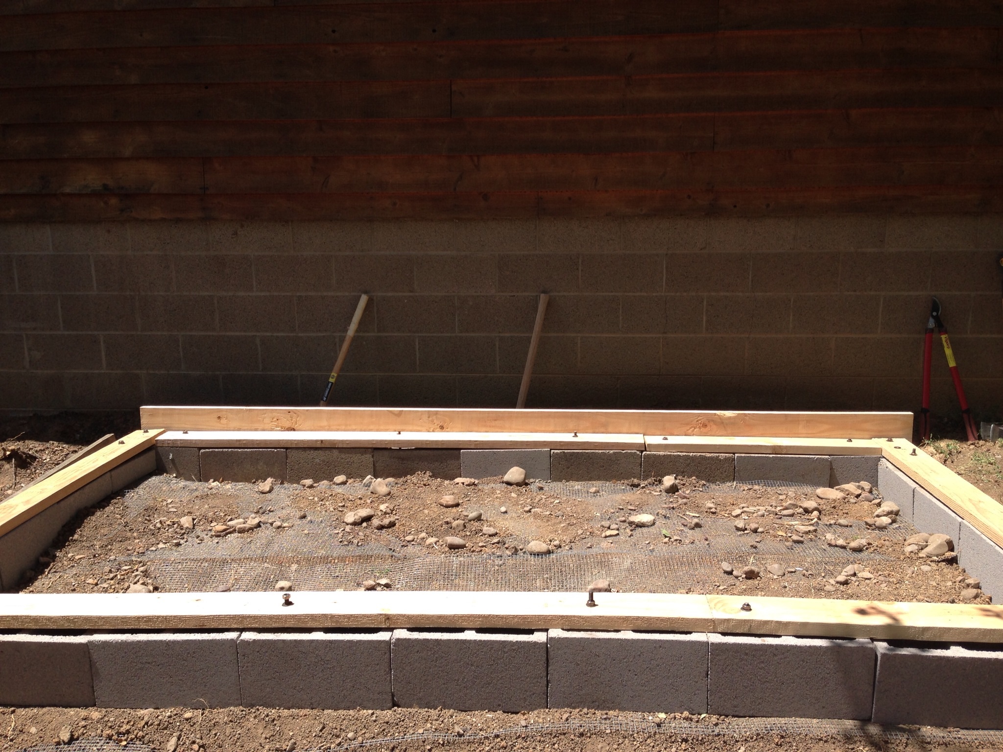 Put 1/2x1/2 hardware cloth on the ground to keep predators out. Hollow blocks then placed 2x6 wood for the foundation.