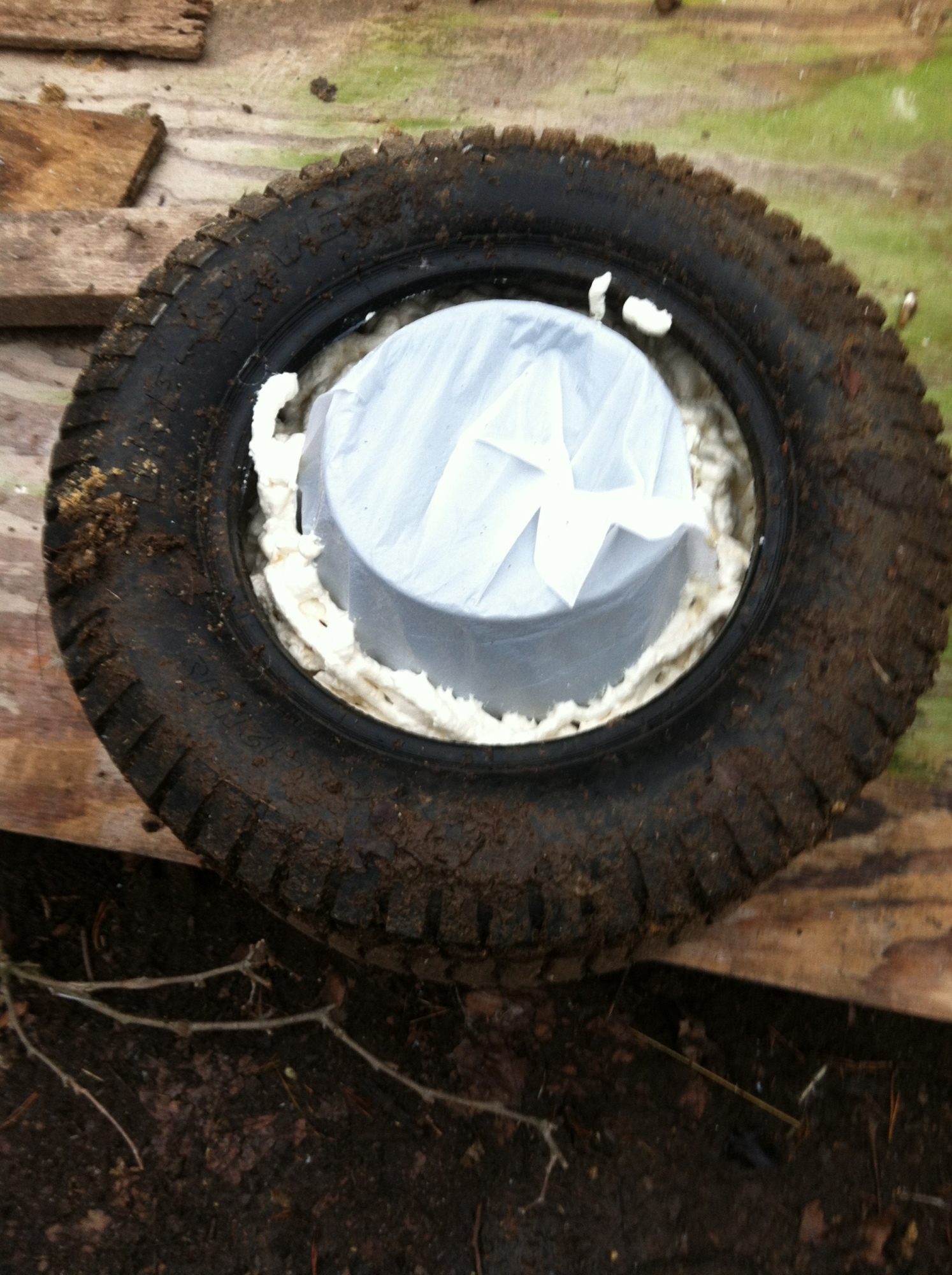 Put the bucket inside the bag. turn upside down and place tire over bucket.
Start filling tire around bucket with foam.