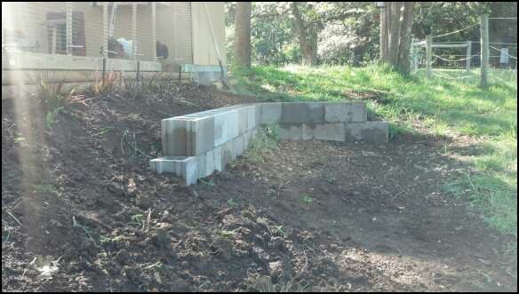 Retaining wall looking west. The grassy area where the shovel is leaning against the building will be where we are going to build an addition to the coop for our breeding pens.