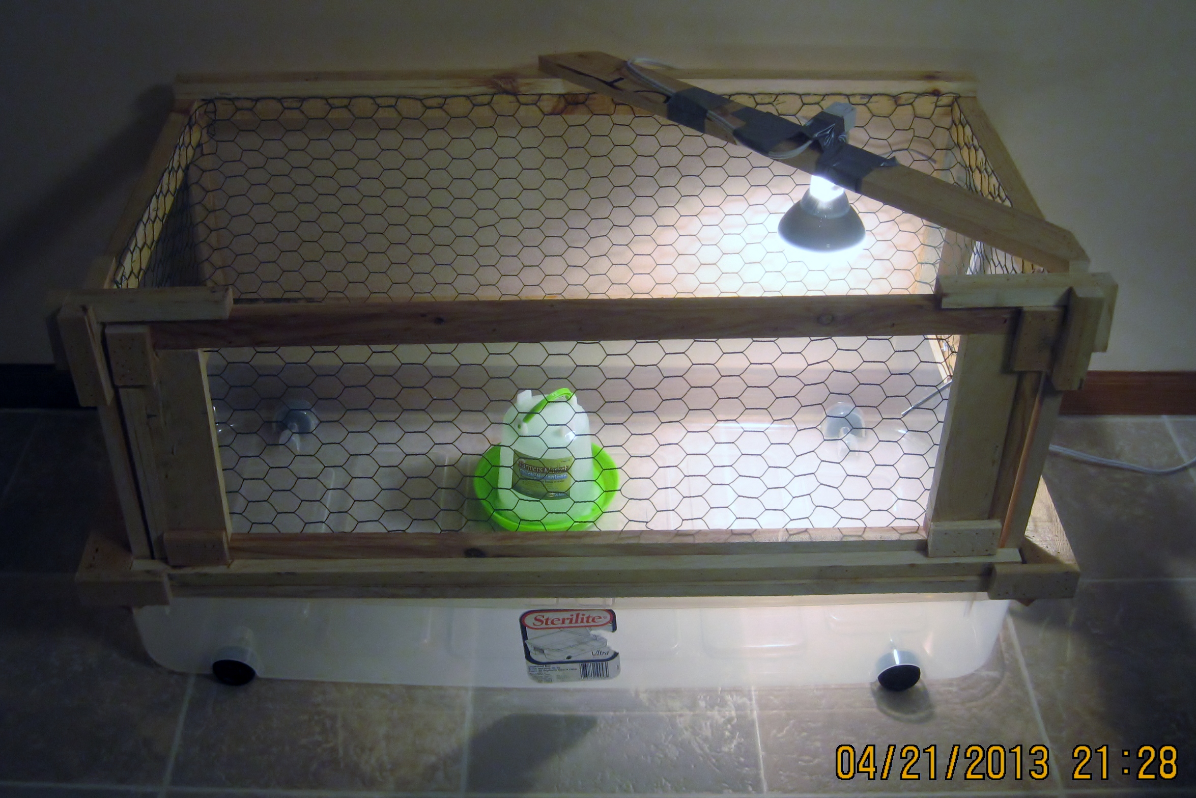 Rubbermaid container, scrap wood, chicken wire and a light
Then put the container cover on top, otherwise in a few weeks, you will find chickens in your dining room