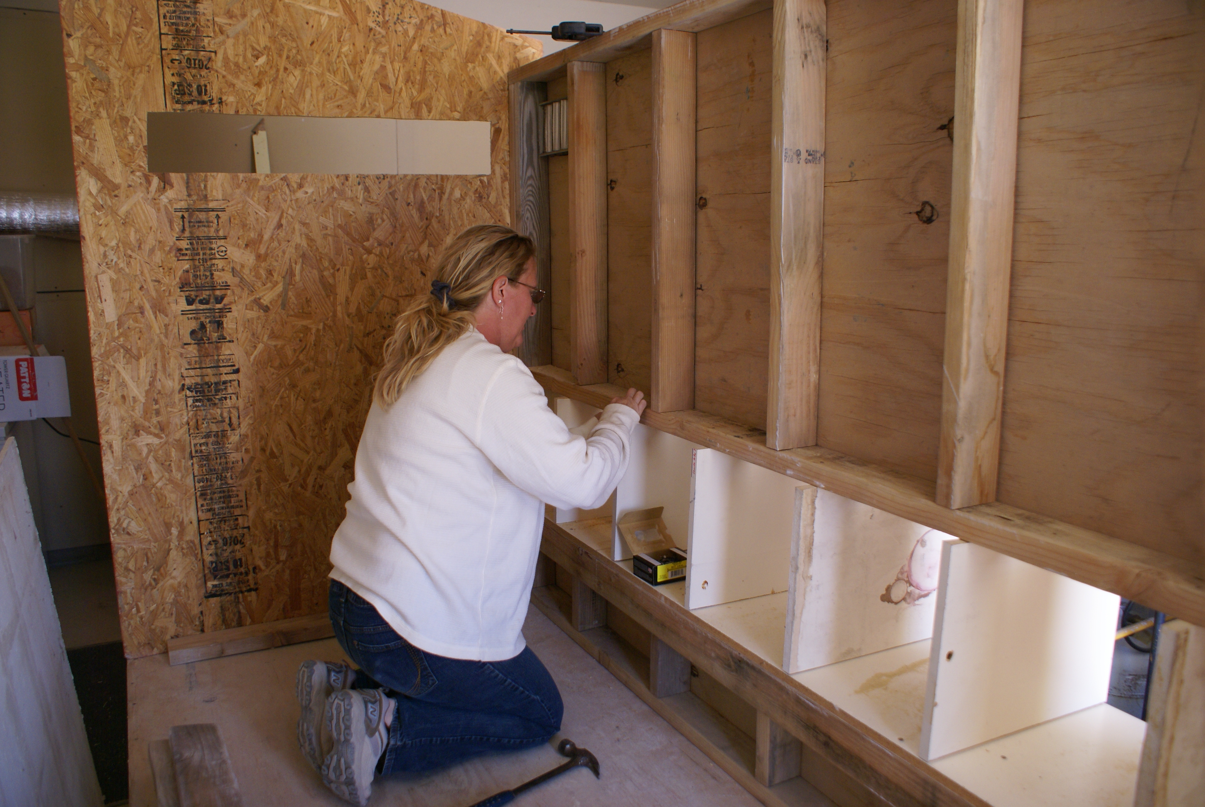 She is working on nailing in the nest boxes.