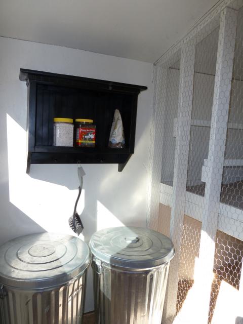 Storage area holds food, scratch and other necessaries.  Had this shelf that I found at a garage sale for $5.  Gave it a couple of coats of black paint and it works perfectly in here!