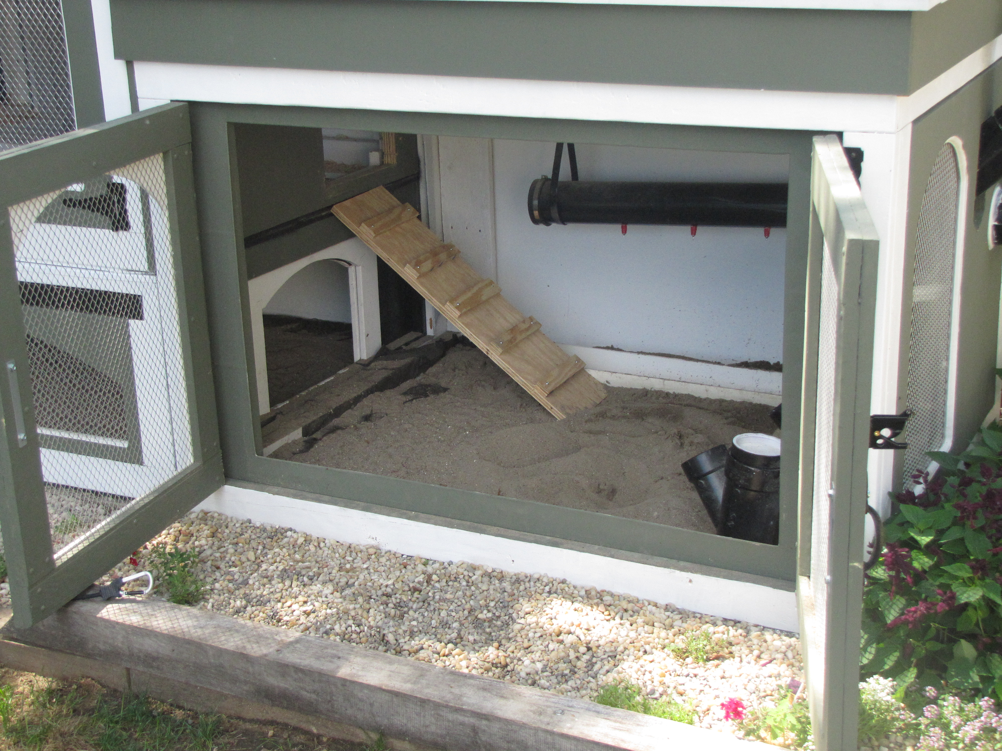 The arched door way gives the chickens access under the coop for more shelter; they often perform dirt bathes in this location

The ladder goes up to the sleeping quarters

Used sand for my foundation/flooring..Easy to clean