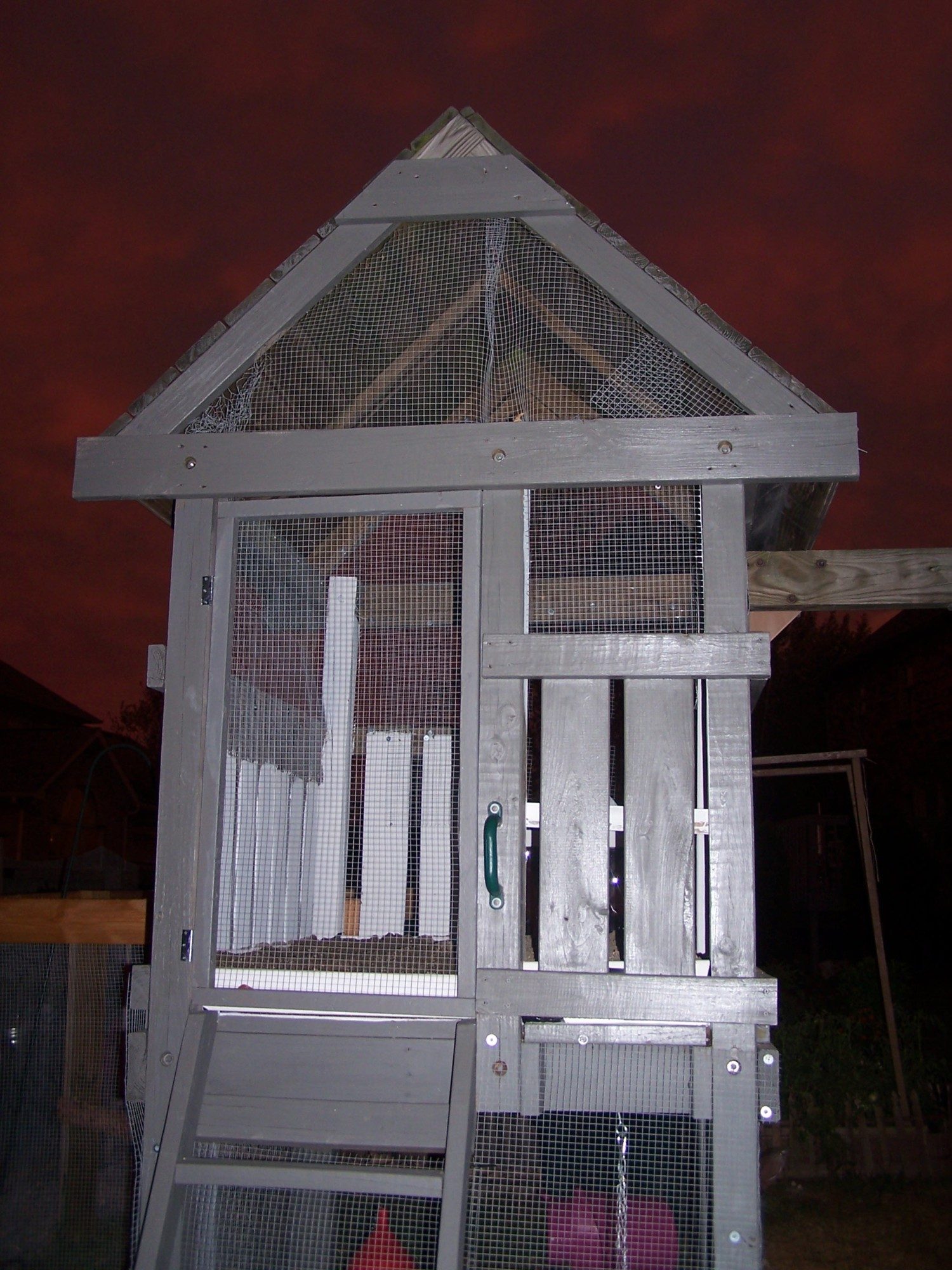 The back of the converted playhouse.  Note how open it is.  The entire coop top to bottom as well as the run are covered in hardware cloth to keep out my ancient basset hound who still effective hunter.  The door is people sized.