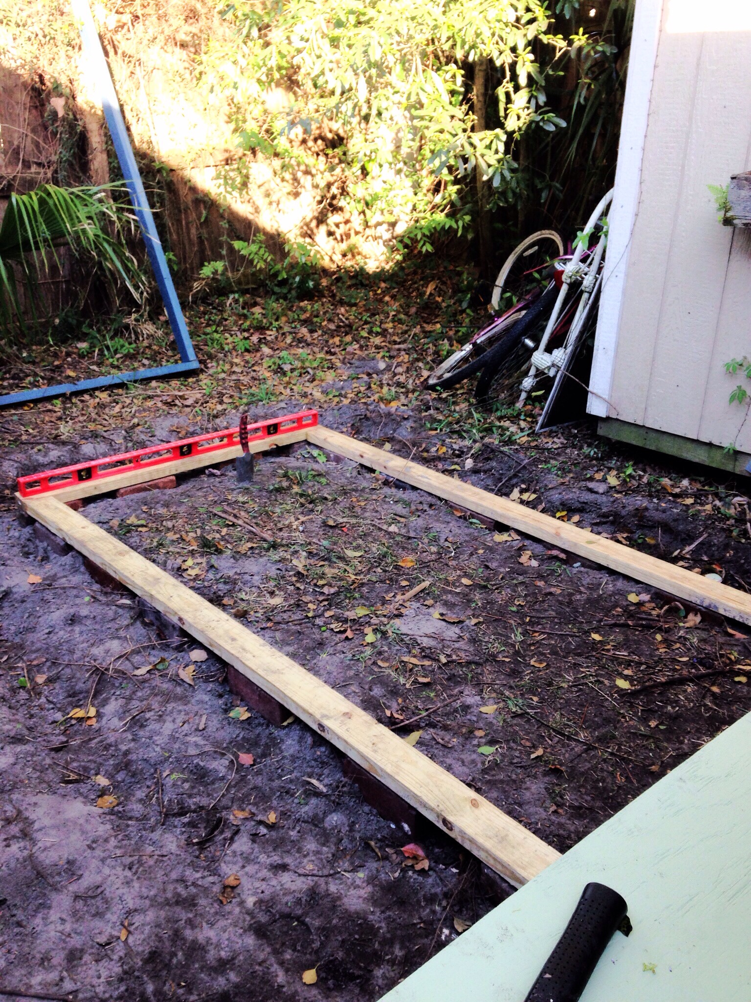 The bricks and pressure treated wood are FINALLY leveled out and ready for the run walls to be raised upon the base.