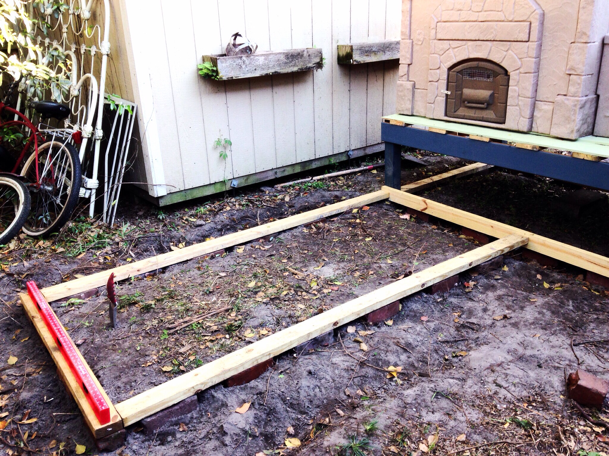 The bricks and pressure treated wood are FINALLY leveled out and ready for the run walls to be raised upon the base.