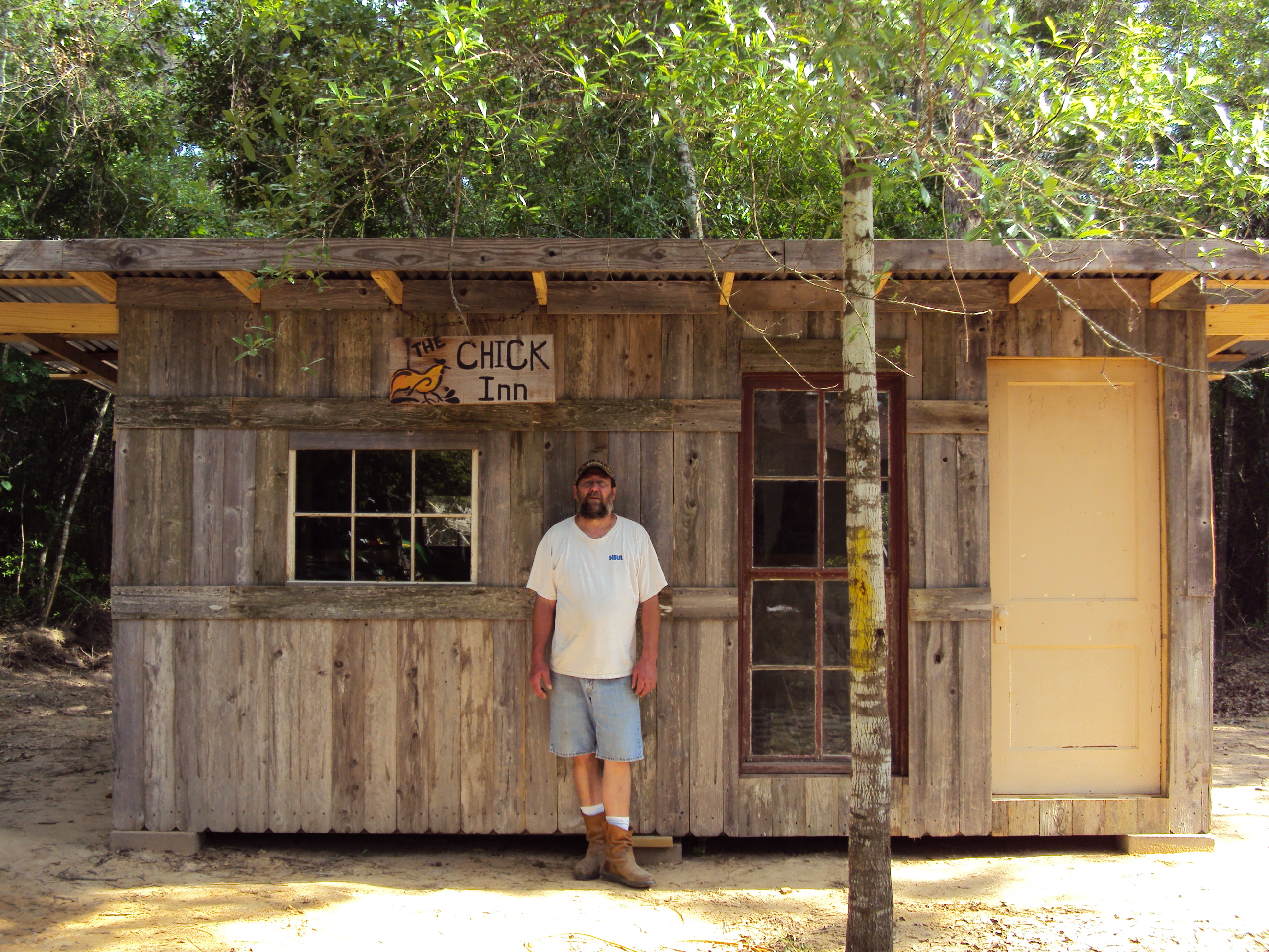 The builder and his masterpiece!  (Almost complete . . . needs front porch!)
The door is from my Grandparents old house that was built in 1939 and the red-trimmed double window from my family's country place - which was built around 1958 by my Dad and Pappy.