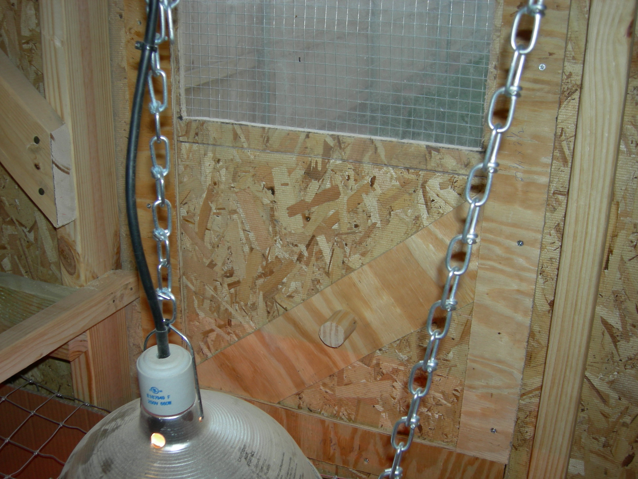The diagonal board under the piece of Plexiglas is the mechanism that holds the window in the closed position. There is a smaller one that allows the window to be slightly open to allow for fresh air to circulate on cooler nights.