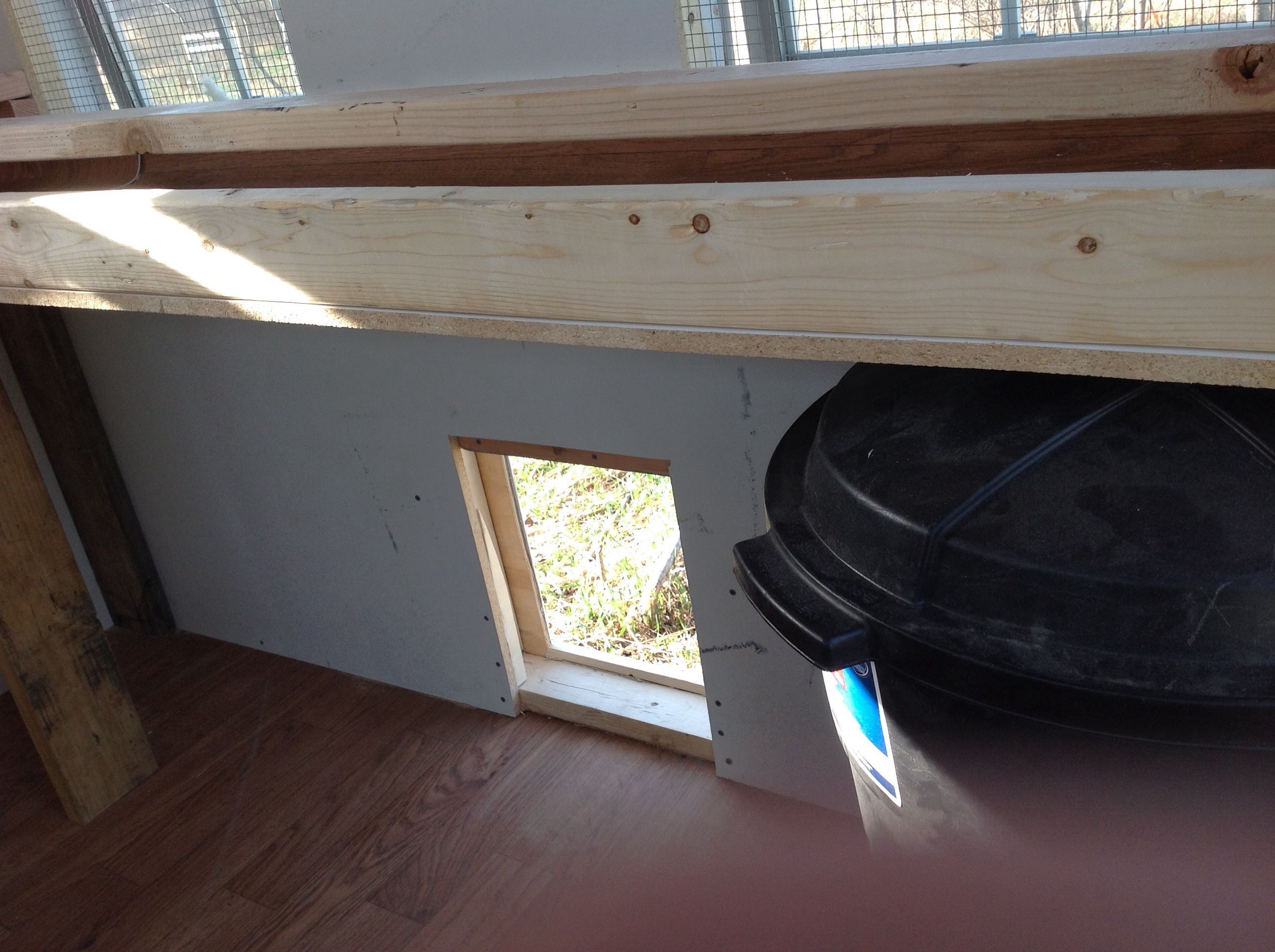 The door under the perch and sand tray.