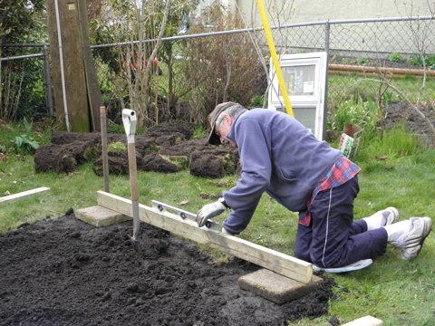 The farmboy is making sure it's nice and level!