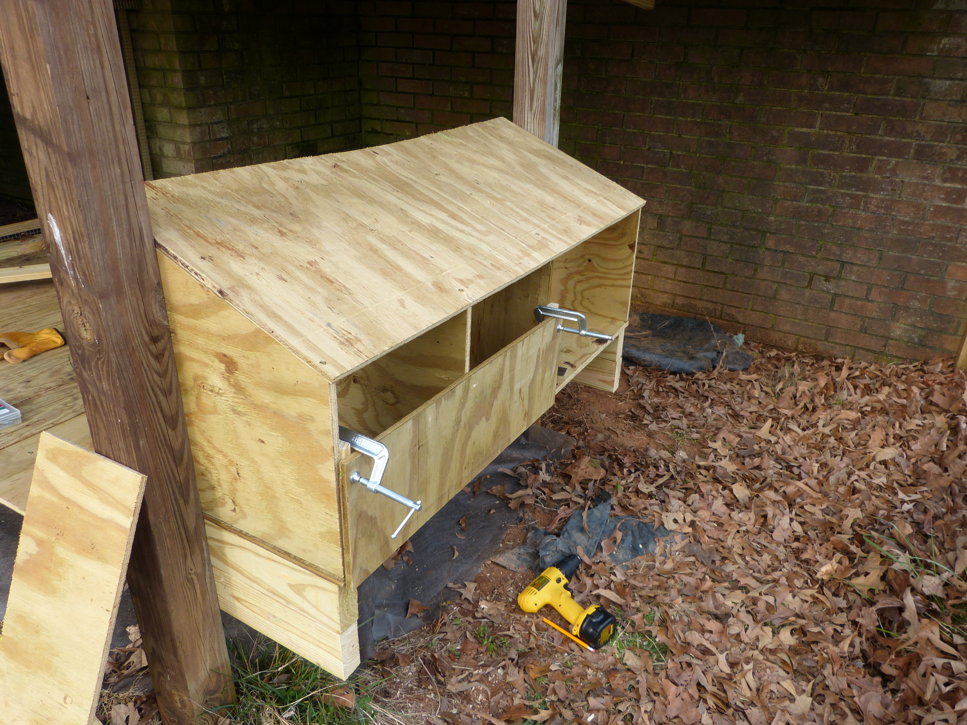 the roof was moved down slope a tad later to correct the bowing and provide a little overhang.  There are two nest boxes and a storage bin with separate door.