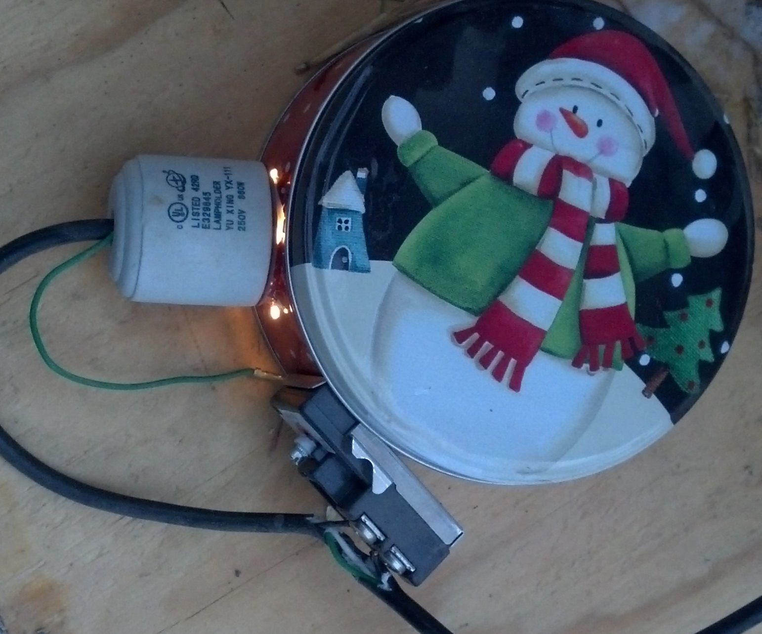 This is a 6 inch Cookie tin with a bulb and thermostat. Total cost $5.00 small heat lamp from Walmart, cooking $2.00, Electric Thermostat (lower) Lowes $8.00. Total cost $15 bucks beats the $40.00 heated waterer. Thermostat turns on light. If it gets too hot it will shut off as a fire prevention. As it cools down, It will turn back on.