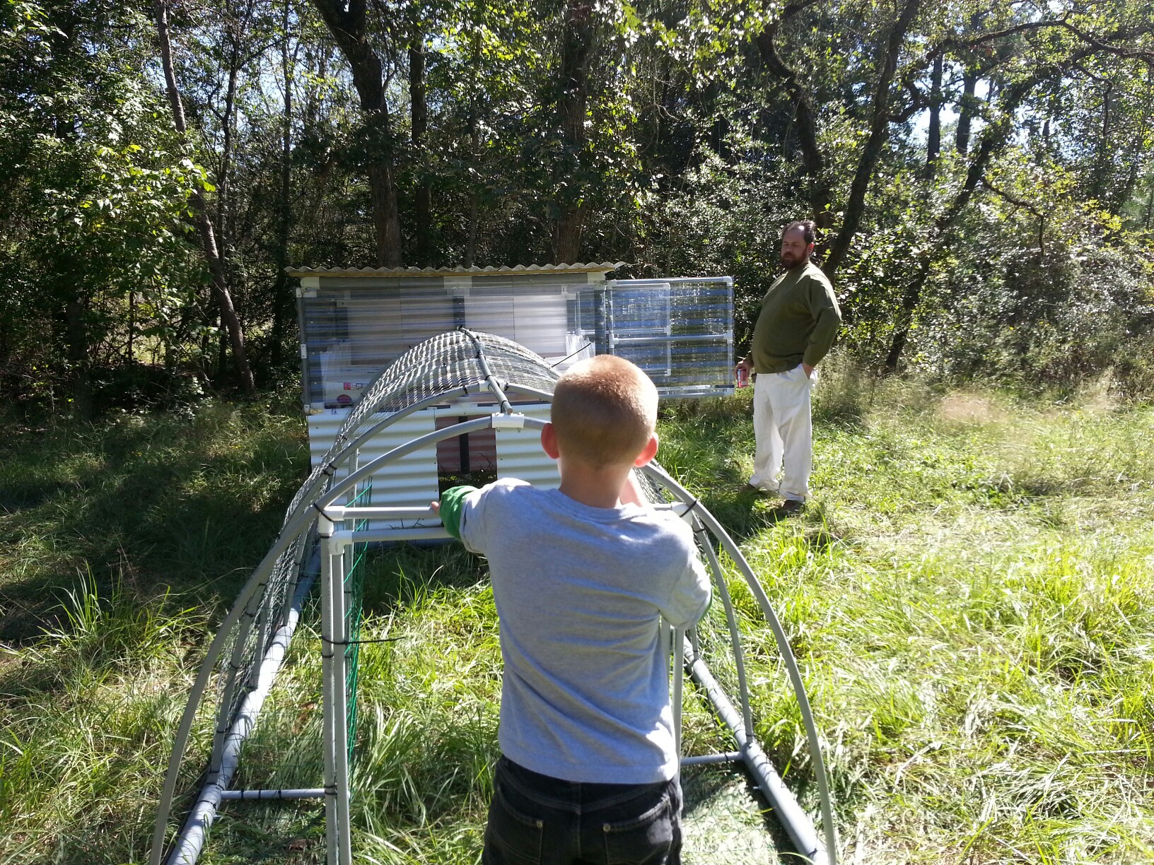 This is my (not quite finished) chicken tractor coop.  Mainly made from PVC pipe.  {My husband and youngest son are also included in the photo}