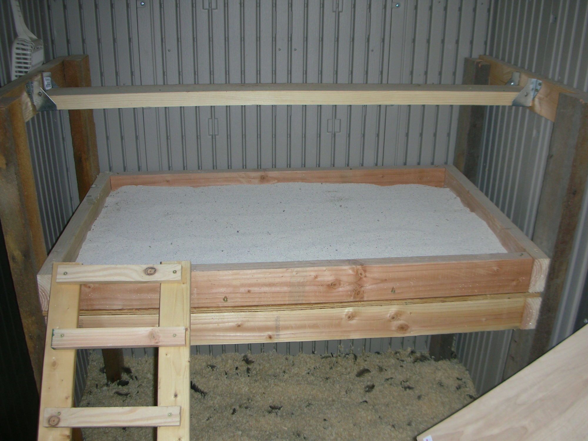 This is my pride and joy! I built this contraption BY MYSELF! Built it outside and my sister helped me get the darn thing into the coop...what a day THAT was! The poop tray is filled with sweet PDZ granular and I can only say if you haven't converted over to this system you're crazy! Best thing I ever did. I just take the kitty litter scooper (up there on the far left) pick up the poops from the previous night...takes all of 3-4 minutes...done! My roost bar is removable using some metal hanger thingies. My BIL sanded and routed the edges so it's real smooth on the girl's feet.
