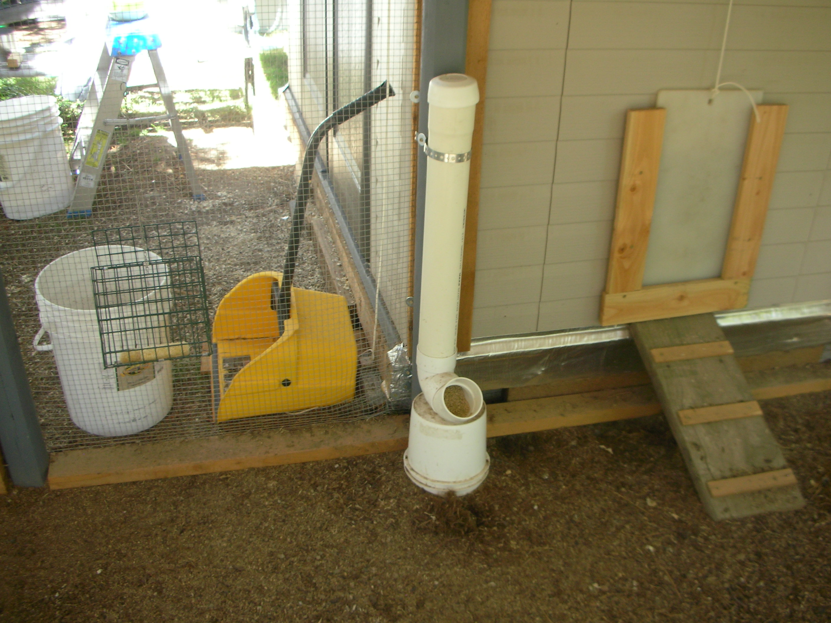 This is one of the PVC tube feeders for the run. Not a finished project yet. Going to add a second one and mount both on scrap pieces of plywood top and bottom, feeders screwed in and set on cinder blocks. Also going to add a second grit/oyster shell cups alongside. The little ramp going to pophole? Another scrap of 2x12 from my BIL, just added slats.