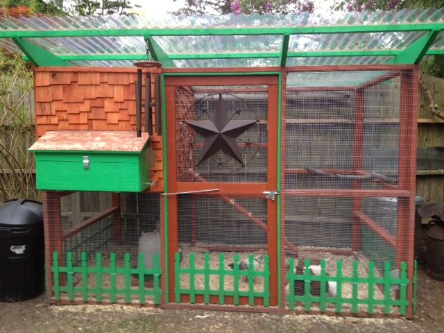 This is the front view of our coop.  It is built from plans from "The Garden Coop", which we used as a guide and embellished to our liking.  Modifications we made are the nesting box on the front of the house with a copper roof, cedar shake shingles, picket fence, and the hen door coming out the side.