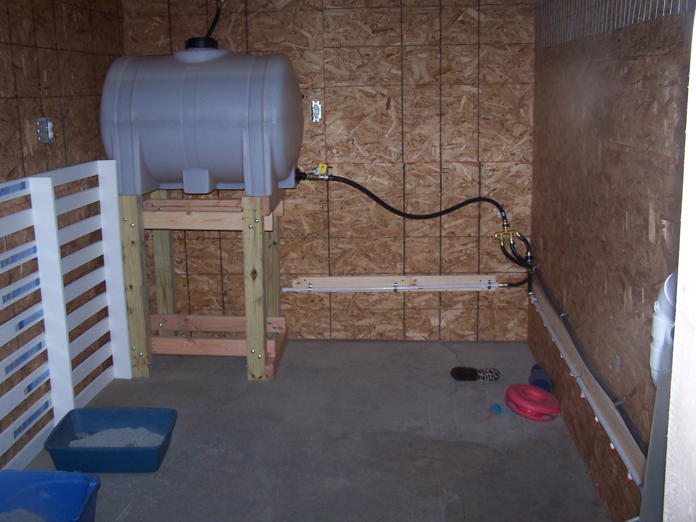 This is the meat chicken area where some kittens were staying for the winter.  The white pallet looking thing will be a low roost for them when layed on the ground.  The water tank to supply nipple waterers