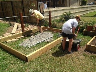 Us shovelling road base to cover the bottom area to not let grass grow through.