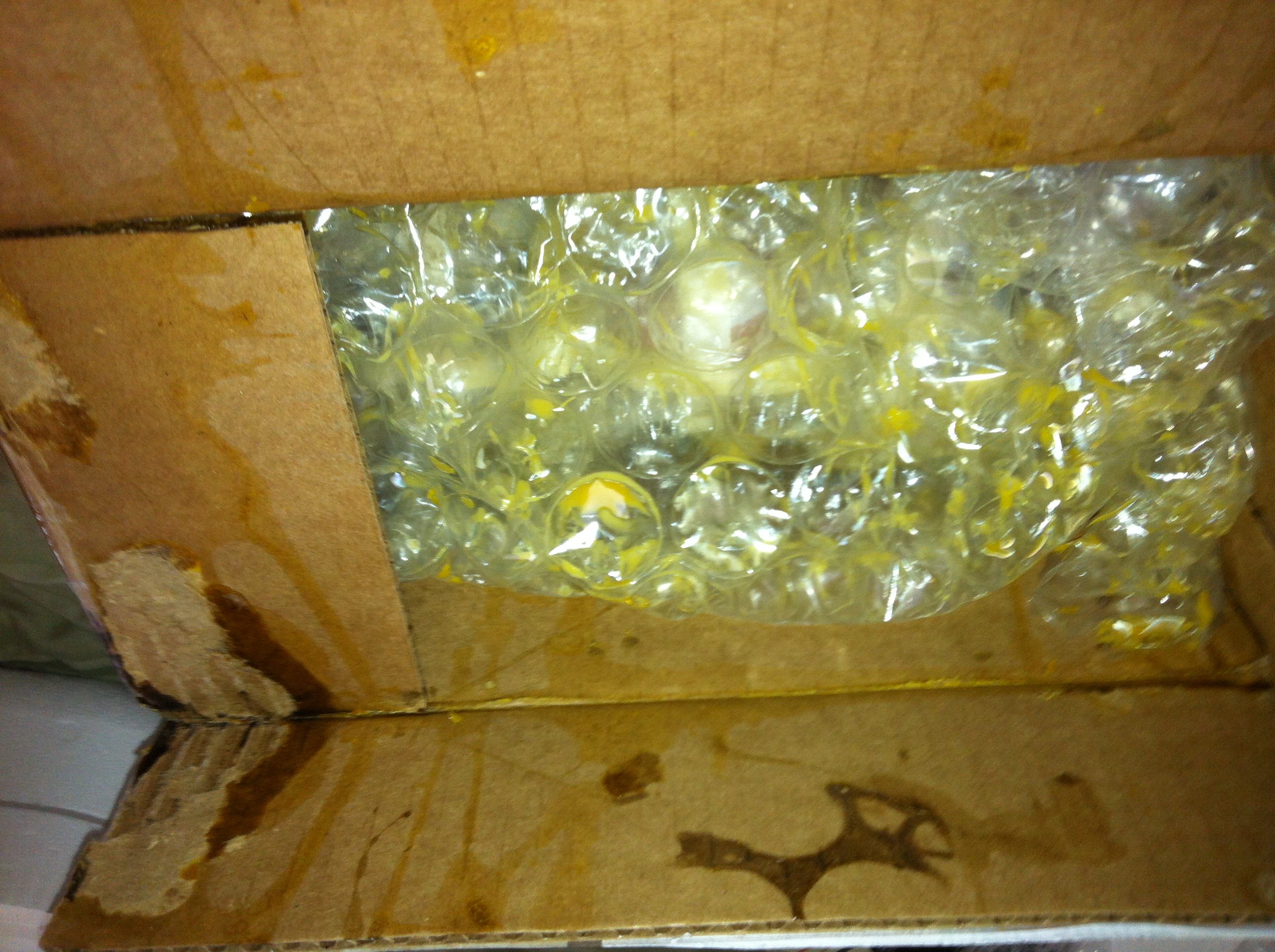 What I saw when I first opened the box. The eggs had obviously broken quite early in their journey, since the yolks had time to dry into a sort of glue that glued the flaps down--I had to tear the cardboard to get the box open!