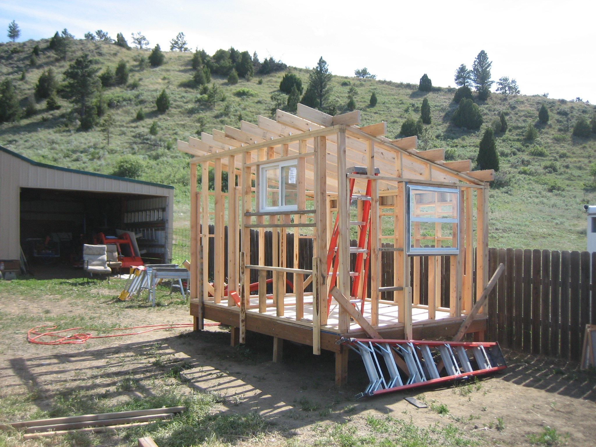 With the walls up, we used 2x6's for the roof.  It took lots of internet reading and emails to my dad to figure out anthing that needed angles.  One window is left over from our barn project and the other is from Habitat's Restore.