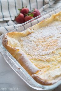 German Pancakes just out of the oven, dusted with powdered sugar in a glass baking dish.
