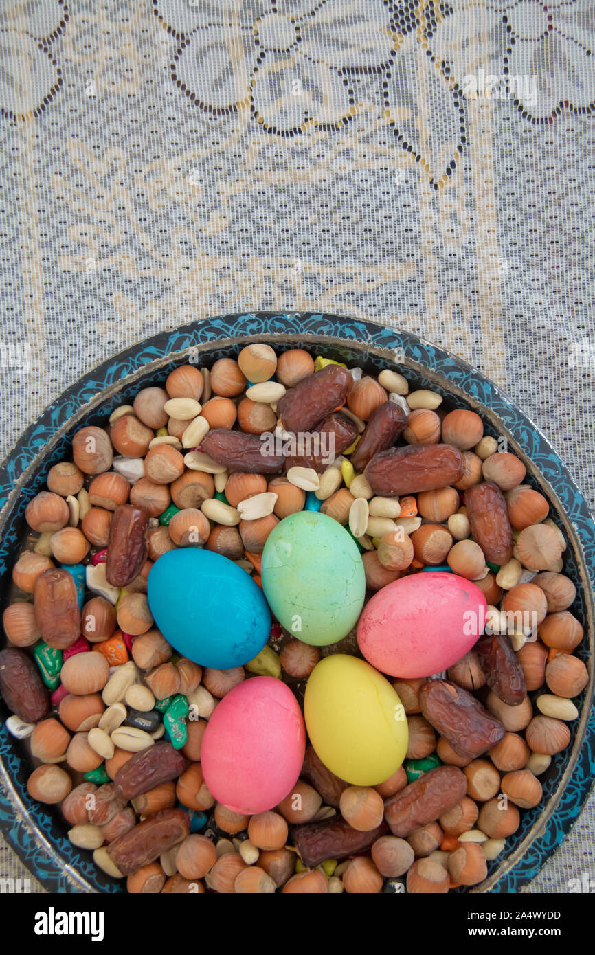 novruz-symbol-on-xoncha-on-white-background-azerbaijan-holiday-there-are-colored-eggs-hazelnuts-dates-and-peanuts-in-the-cabin-2A4WYDD.jpg